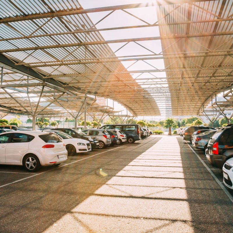 Cars on a covered parking lot in sunny summer day